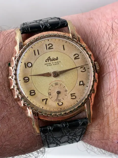 Reloj Aries vintage de cuerda con caja trabajada y esfera patinada